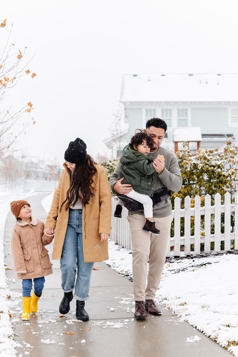 family using tushbaby hip carrier to carry their child