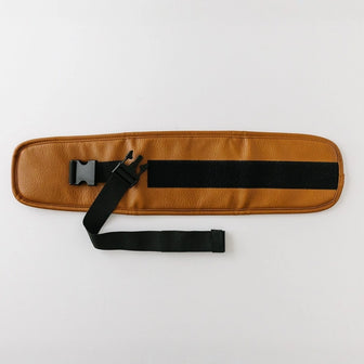 The Waistband Extender in Cognac laid flat, showing the adjustable black strap, buckle, and hook-and-loop fastening panel