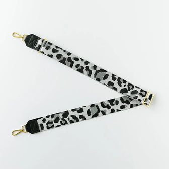 The Crossbody Strap in Leopard laid flat with gold snap hooks and an adjustable gold slider against a white background