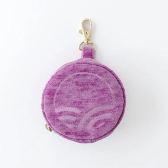 The Pod in Orchid with textured velvet, a logo, and a gold-tone clip on a light background