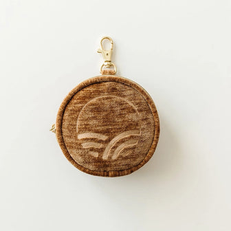 The Pod in Sable with textured velvet, a logo, and a gold-tone clip on a light background
